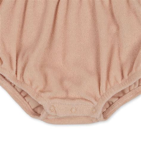 Detailfoto van de drukknoopjes en de enveloppehals van een baby romper.
