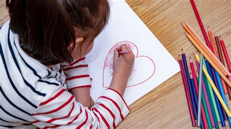 Illustratie van een kind dat aan een witte kindertafel met stoeltjes zit te tekenen.