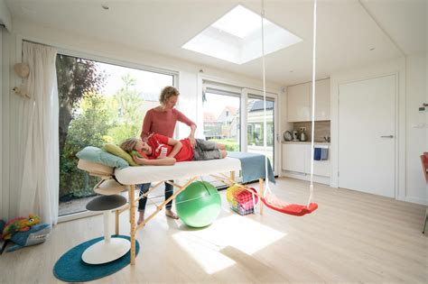 Foto van een warme en huiselijke praktijkruimte met een bank en tijdschriften