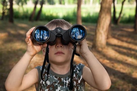 Een kind dat een opgevouwen verrekijker vasthoudt, met een koord zichtbaar