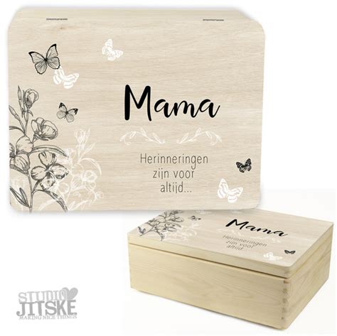 Een mooi versierde houten herinneringsdoos met baby spulletjes erin