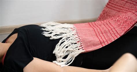 Afbeelding van een vrouw die zachtjes wordt ingewikkeld in doeken tijdens een Rebozo sluitingsritueel.