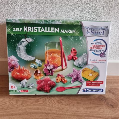 Illustratie van verschillende Buki experimenteerdozen met diverse thema's zoals kristallen maken, vulkaanuitbarstingen en natuuronderzoek.