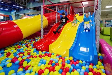 Een kleurrijke ballenbak met een foam glijbaan en diverse foam zitjes in dierenvorm.