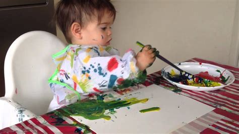 Een kind dat met zijn handen in verf aan het schilderen is.