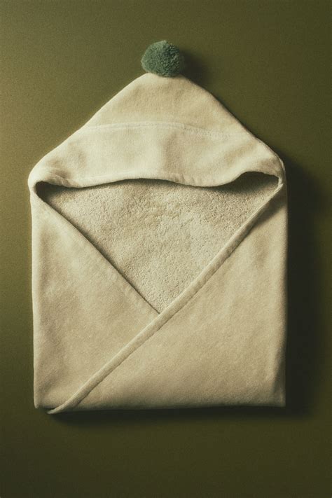 Detail van de zachte badstof van de babybadcape en een borduurmachine