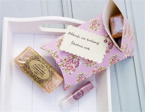Kompilace různých typů děkovných dárků k narození, včetně cukrovinek, mýdel, mini rostlinek a figurek štěstí.