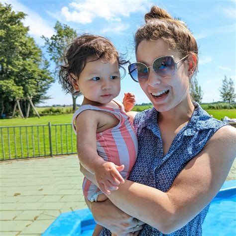 Amber Brantsen lachend, met een zichtbare babybuik, in een studio-omgeving