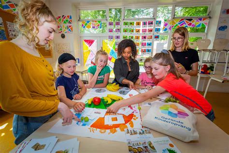 Foto van lachende kinderen tijdens een knutselactiviteit op een kinderdagverblijf.