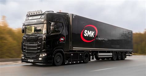 Foto van een moderne vrachtwagen met een strakke, professionele belettering van SMK Logistics.
