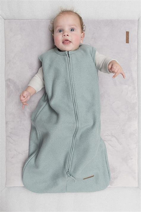 Een baby die comfortabel in een slaapzak ligt, zonder spijkerbroek