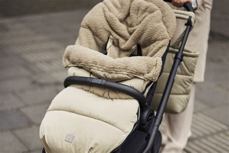 Baby in een wollen voetenzak in een kinderwagen