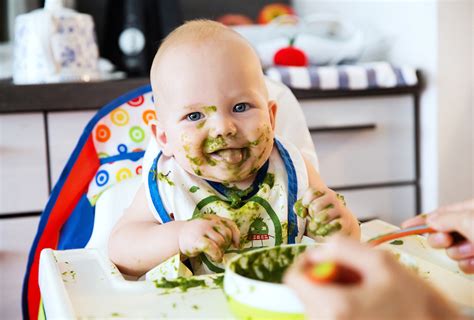 Afbeelding van een baby die met plezier groente eet