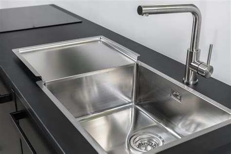 Infographic met een stappenplan voor het reinigen van een RVS spoelbak met huismiddeltjes.