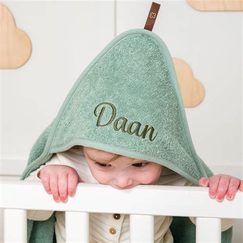 Voorbeeld van een baby badcape geborduurd met een naam in verschillende kleuren