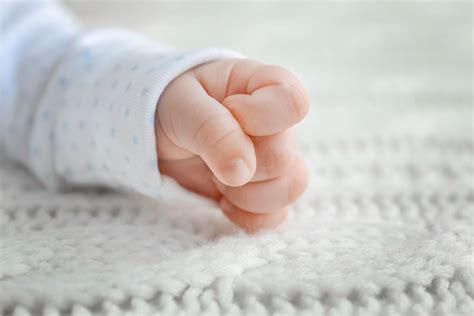 baby die aan het sabbelen is op zijn handje