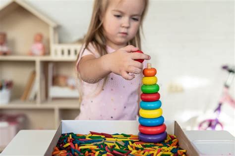 Een kind dat enthousiast speelt met een houten speelgoedkeuken.