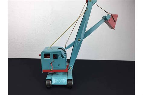 Illustratie van de USSR speelgoed kraan van geperst staal, met nadruk op de beweegbare cabine en rupsbanden.