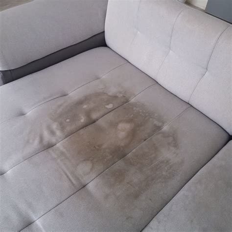 Reinigen van een vlek op een stoffen bank met een milde oplossing